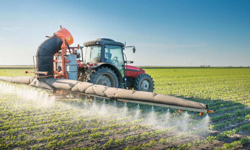 Image of pesticide applicator on large crop field to show how pesticides contribute to Nitrate in Groundwater